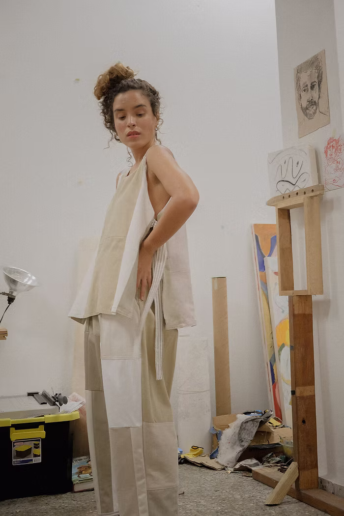 Person in artistic studio wearing beige outfit.